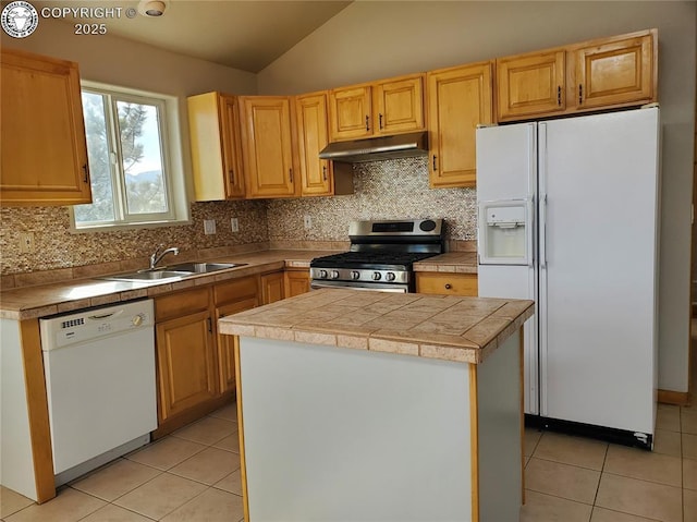 kitchen featuring light tile patterned floors, under cabinet range hood, white appliances, a kitchen island, and a sink