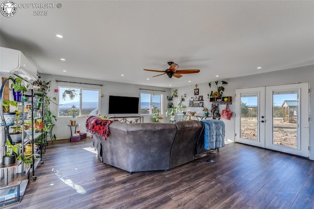 living room featuring an AC wall unit, dark hardwood / wood-style floors, ceiling fan, and french doors