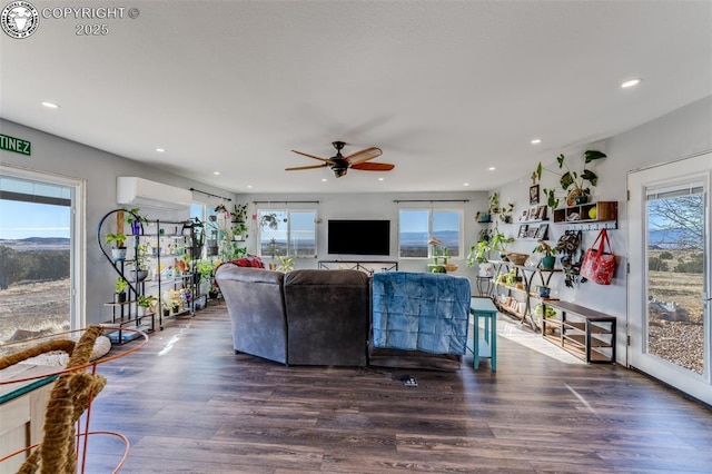 living room with a wall mounted air conditioner, dark hardwood / wood-style floors, and ceiling fan