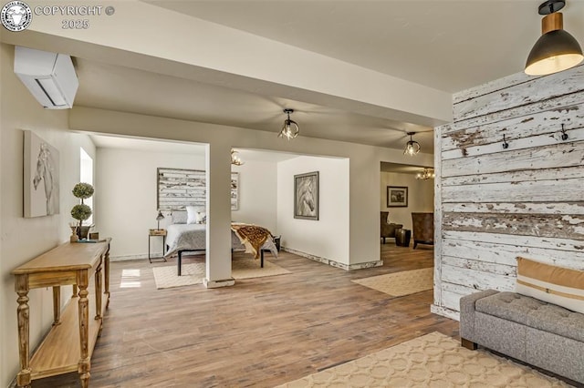 sitting room with wood walls, a wall mounted air conditioner, and light wood-style floors