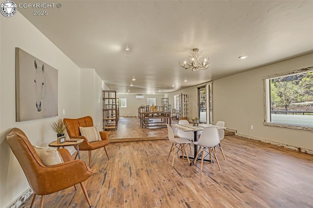 dining space with a chandelier, recessed lighting, and wood finished floors