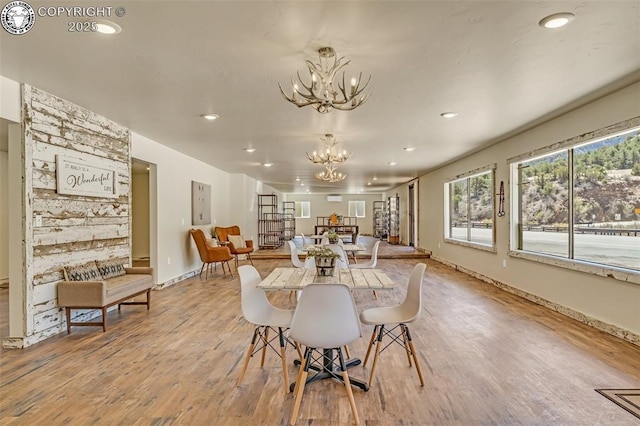 dining room with recessed lighting, wood finished floors, baseboards, and a chandelier