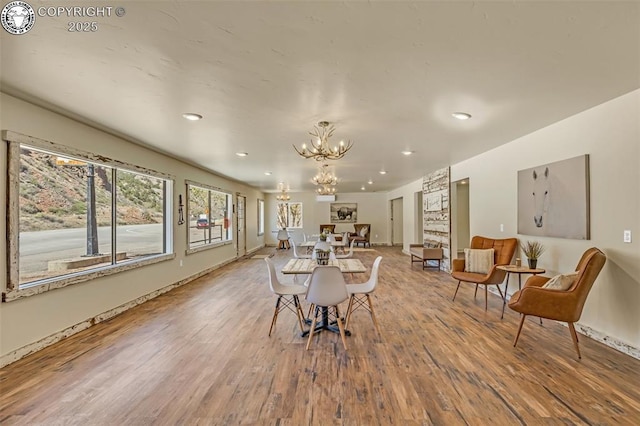 dining area with a notable chandelier, wood finished floors, and recessed lighting