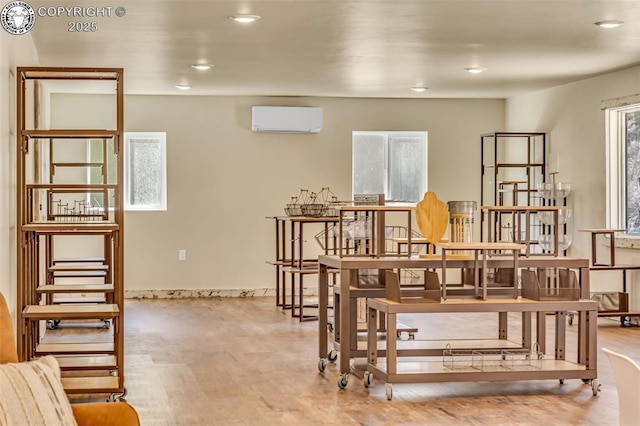 interior space with recessed lighting, wood finished floors, and a wall unit AC