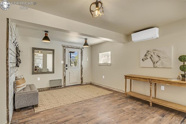 foyer featuring a wall mounted air conditioner, baseboards, and wood finished floors