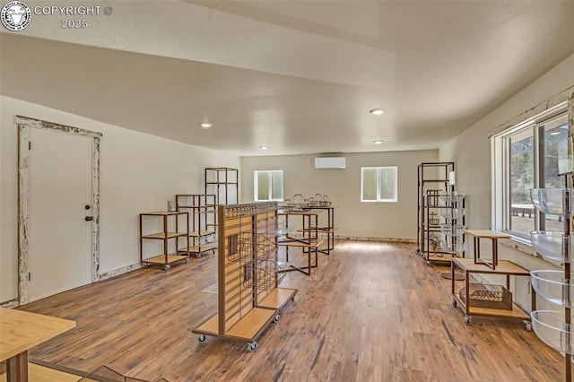 interior space featuring recessed lighting, wood finished floors, and a wall mounted AC