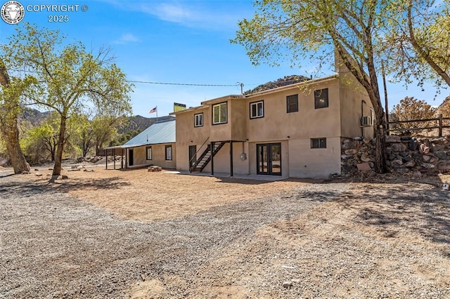 rear view of house featuring french doors and fence