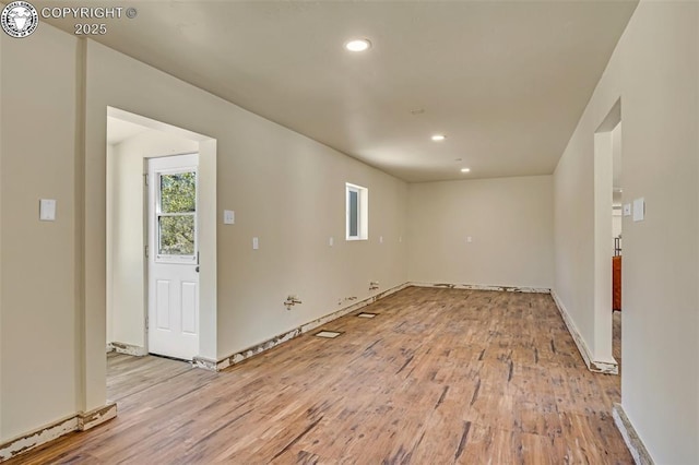 spare room featuring recessed lighting, light wood-type flooring, and baseboards