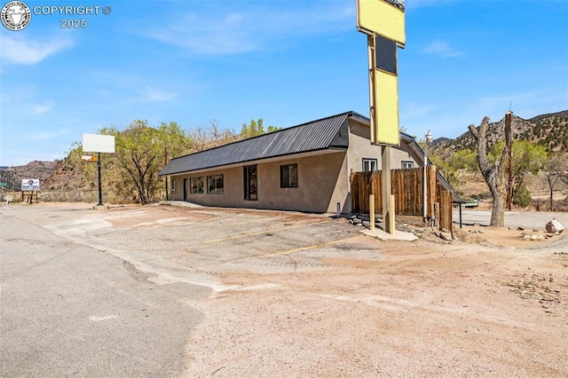 view of property featuring a mountain view, uncovered parking, and fence