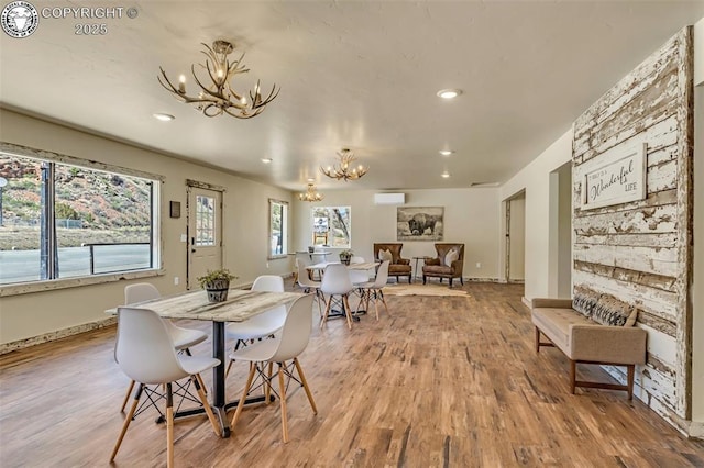 dining room with an inviting chandelier, recessed lighting, wood finished floors, and baseboards