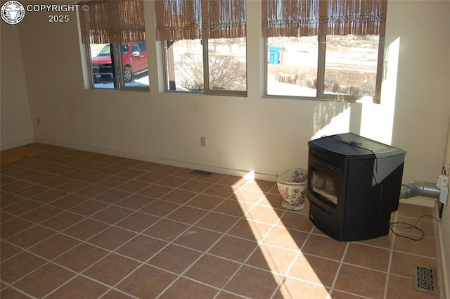 tiled empty room with a wood stove