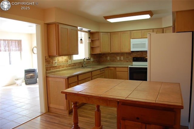 kitchen with a wealth of natural light, sink, tile counters, and white appliances