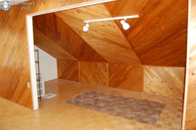 bonus room featuring wooden ceiling and wood walls