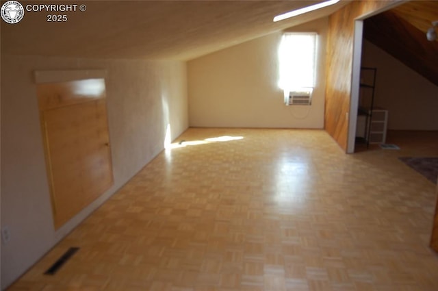 additional living space featuring lofted ceiling and light parquet flooring