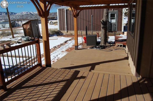 snow covered deck with a mountain view