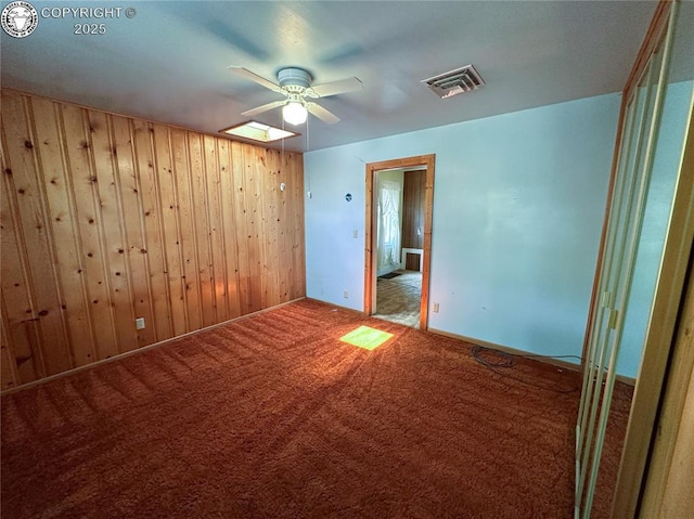 720 Whipple Ave, Canon City, CO 81212 - carpeted empty room with a ceiling fan and wood walls