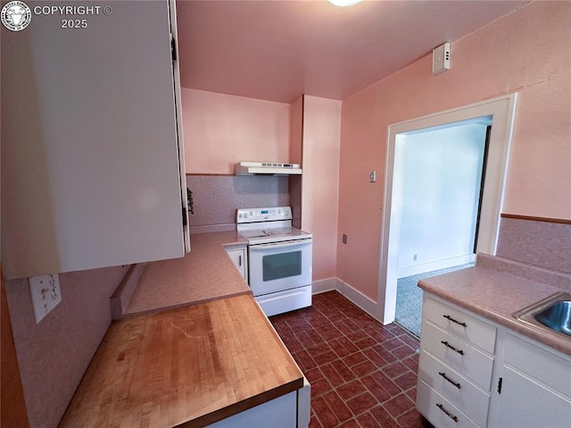 720 Whipple Ave, Canon City, CO 81212 - kitchen with electric range, under cabinet range hood, white cabinets, brick patterned floors, and wooden counters