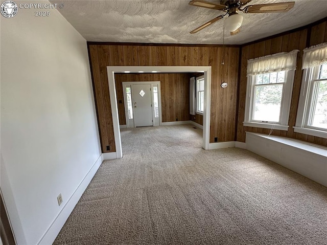 720 Whipple Ave, Canon City, CO 81212 - spare room featuring wood walls, ceiling fan, and light colored carpet
