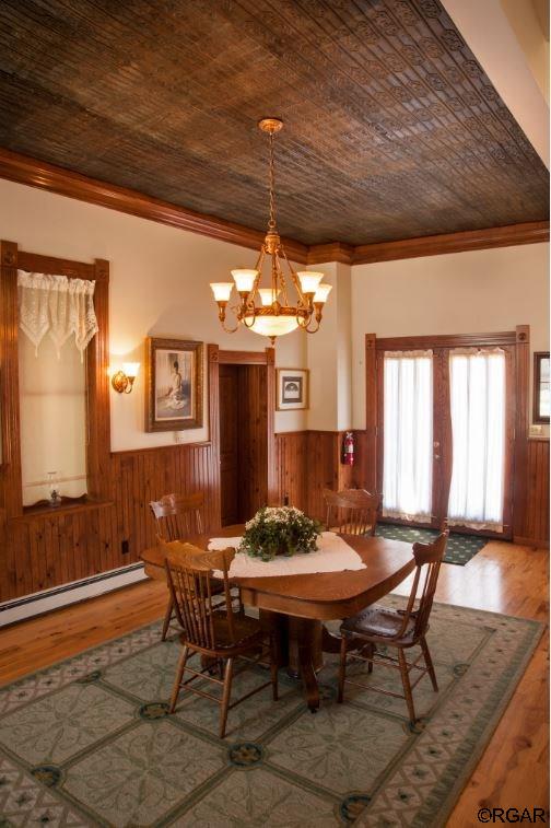 dining area featuring hardwood / wood-style flooring, ornamental molding, wooden ceiling, and a chandelier