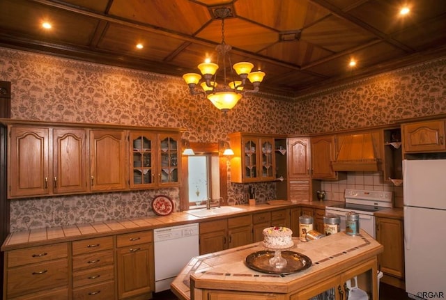 kitchen featuring tile counters, sink, white appliances, and custom exhaust hood