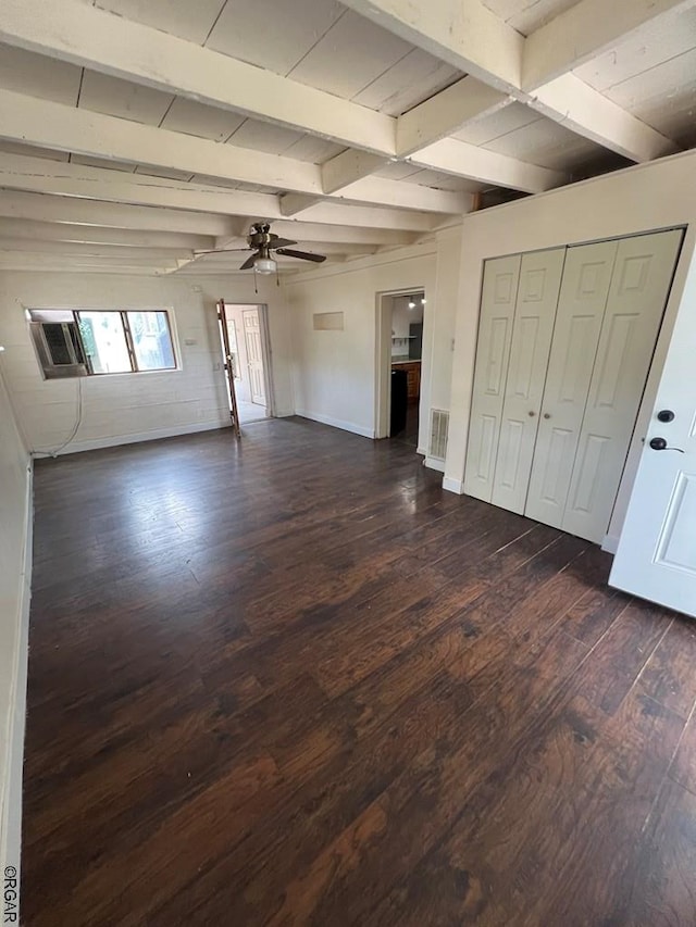 unfurnished living room featuring dark hardwood / wood-style flooring, beam ceiling, and ceiling fan