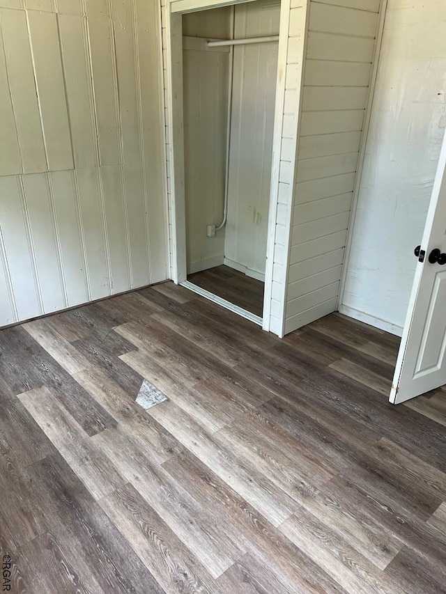 unfurnished bedroom featuring dark hardwood / wood-style flooring and a closet