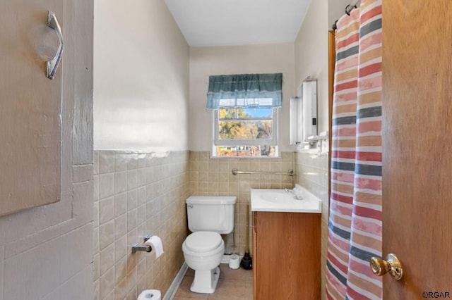 bathroom with tile patterned flooring, vanity, tile walls, and toilet