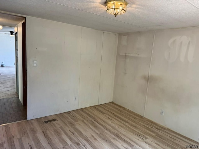 empty room featuring a textured ceiling and light wood-type flooring