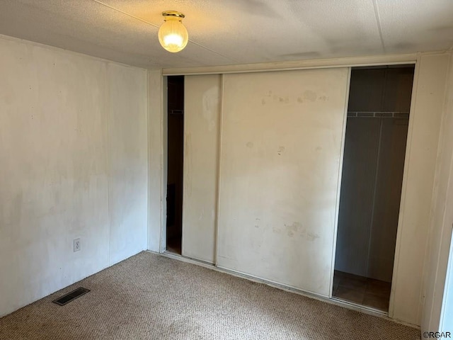 unfurnished bedroom with carpet flooring and a closet