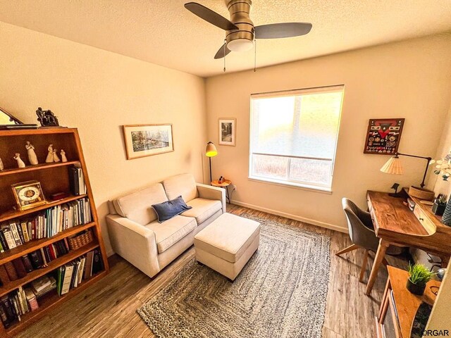 sitting room with wood-type flooring, a textured ceiling, and ceiling fan