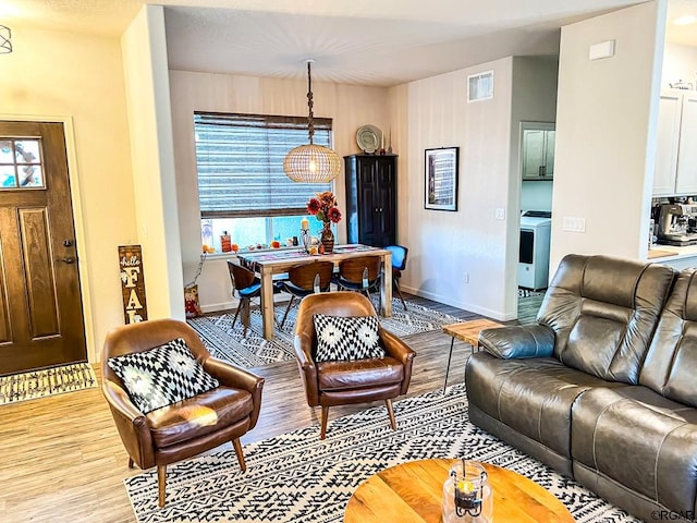 living room featuring washer / dryer and light hardwood / wood-style floors