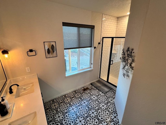 bathroom featuring tile patterned floors, a shower with door, a textured ceiling, and vanity