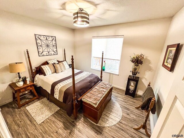 bedroom with hardwood / wood-style flooring and a textured ceiling