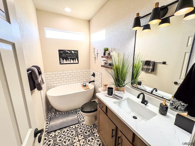 bathroom featuring vanity, tile patterned flooring, a tub, and toilet