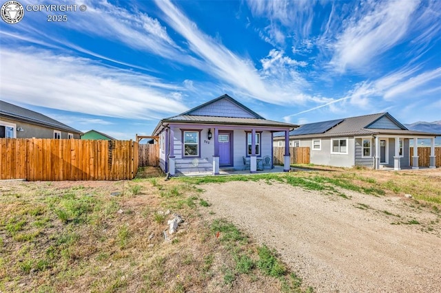 202 First St, Silver Cliff, CO 81252 - view of front of house featuring a porch, a metal roof, and solar panels
