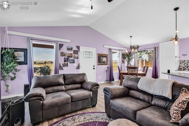 202 First St, Silver Cliff, CO 81252 - living room featuring lofted ceiling, a chandelier, light wood-style flooring, and a ceiling fan