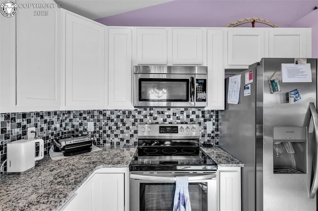 202 First St, Silver Cliff, CO 81252 - kitchen featuring stainless steel appliances, backsplash, light stone countertops, white cabinets, and vaulted ceiling