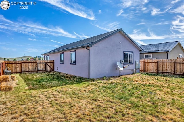 202 First St, Silver Cliff, CO 81252 - rear view of property featuring a fenced backyard, a metal roof, and stucco siding