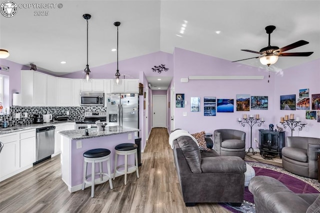 202 First St, Silver Cliff, CO 81252 - kitchen featuring stainless steel appliances, open floor plan, lofted ceiling, a center island, and white cabinetry