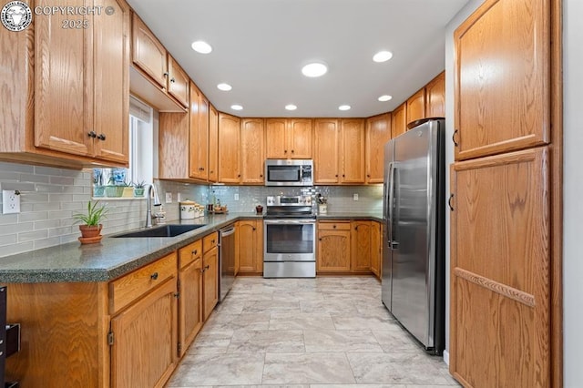 kitchen with a sink, stainless steel appliances, tasteful backsplash, and brown cabinetry