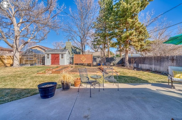 view of patio with an outdoor structure, a vegetable garden, and a fenced backyard