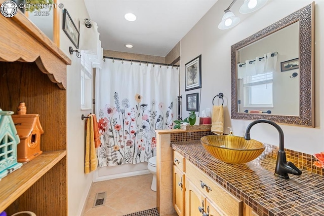 bathroom featuring visible vents, toilet, shower / bath combo with shower curtain, tile patterned floors, and vanity