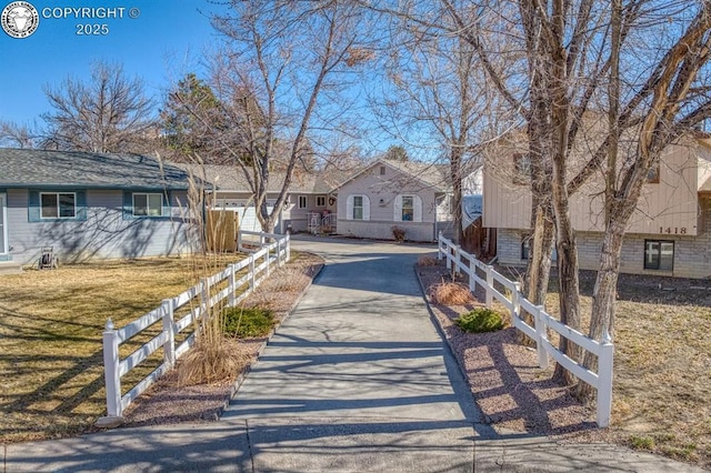 view of front of house featuring a front yard, fence, a residential view, and driveway