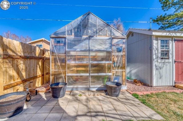 view of greenhouse featuring fence private yard