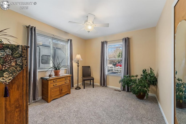 sitting room with visible vents, light colored carpet, baseboards, and ceiling fan