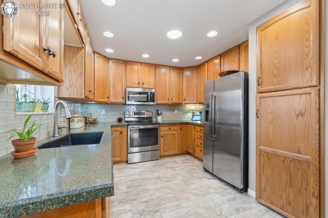 kitchen with a sink, backsplash, appliances with stainless steel finishes, and recessed lighting