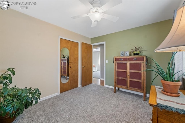 sitting room with baseboards, a ceiling fan, and carpet