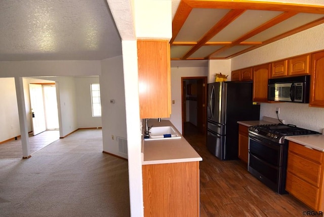 kitchen featuring black refrigerator, sink, gas range, and dark carpet