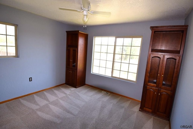 unfurnished bedroom featuring ceiling fan and light carpet