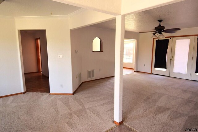 empty room with ceiling fan, ornamental molding, light carpet, and a textured ceiling